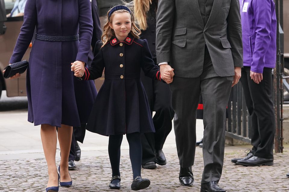 Mia Grace Tindall holding the hands of her father, Mike Tindall, and her mother, Zara Tindall. 