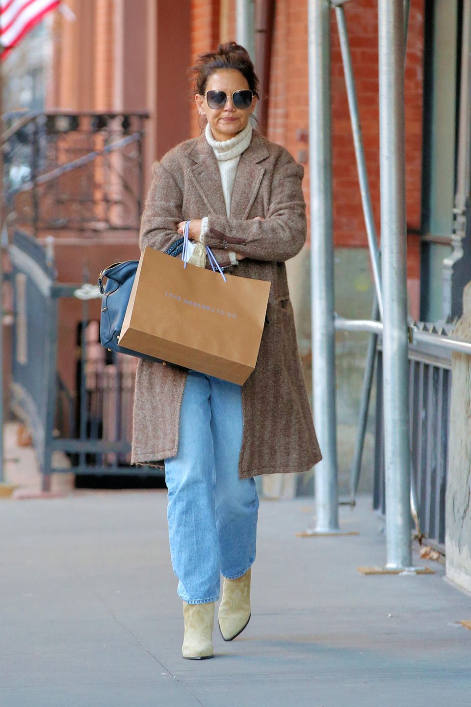 Auf den Straßen New Yorks beweist Schauspielerin Katie Holmes wieder einmal, wie stilsicher sie ist. In einem Mantel aus Tweed, einem hellen Rollkragen-Pullover und mit Messy Bun verkörpert sie scheinbar mühelos den Inbegriff vom New Yorker Streetstyle. Helle Cowboy-Stiefel sowie eine XL-Sonnenbrille runden ihren coolen Look ab.