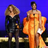Ein Duo von dem man bei den Grammys 2021 nicht die Augen wenden kann: Beyoncé und Megan Thee Stallion präsentieren auf der Bühne zwei völlig verschiedene Looks. Beyoncé trägt ein kurzes Lederdress und Megan begeistert in einem leuchtenden Orange aus dem Haus Dolce & Gabanna. 