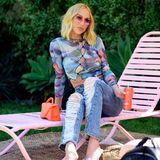 Auch Netflix-Star Christine Quinn wärmt sich mit einem Drink für das Wochenende auf. Dabei trägt sie eine lässige Jeans mit Destroyed-Look und ein halbtransparentes Shirt mit wildem Muster.