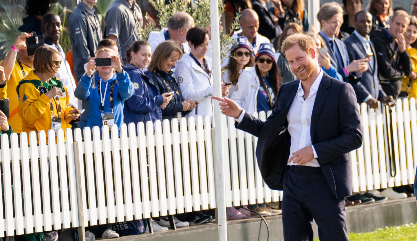Auch Prinz Harry zeigt sich bestens gelaunt und begrüßt wartenden Fans in der Menge.