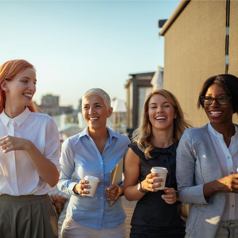 Vier Frauen lachen: Warum wir gerne tratschen – und welche wichtige soziale Funktion es erfüllt