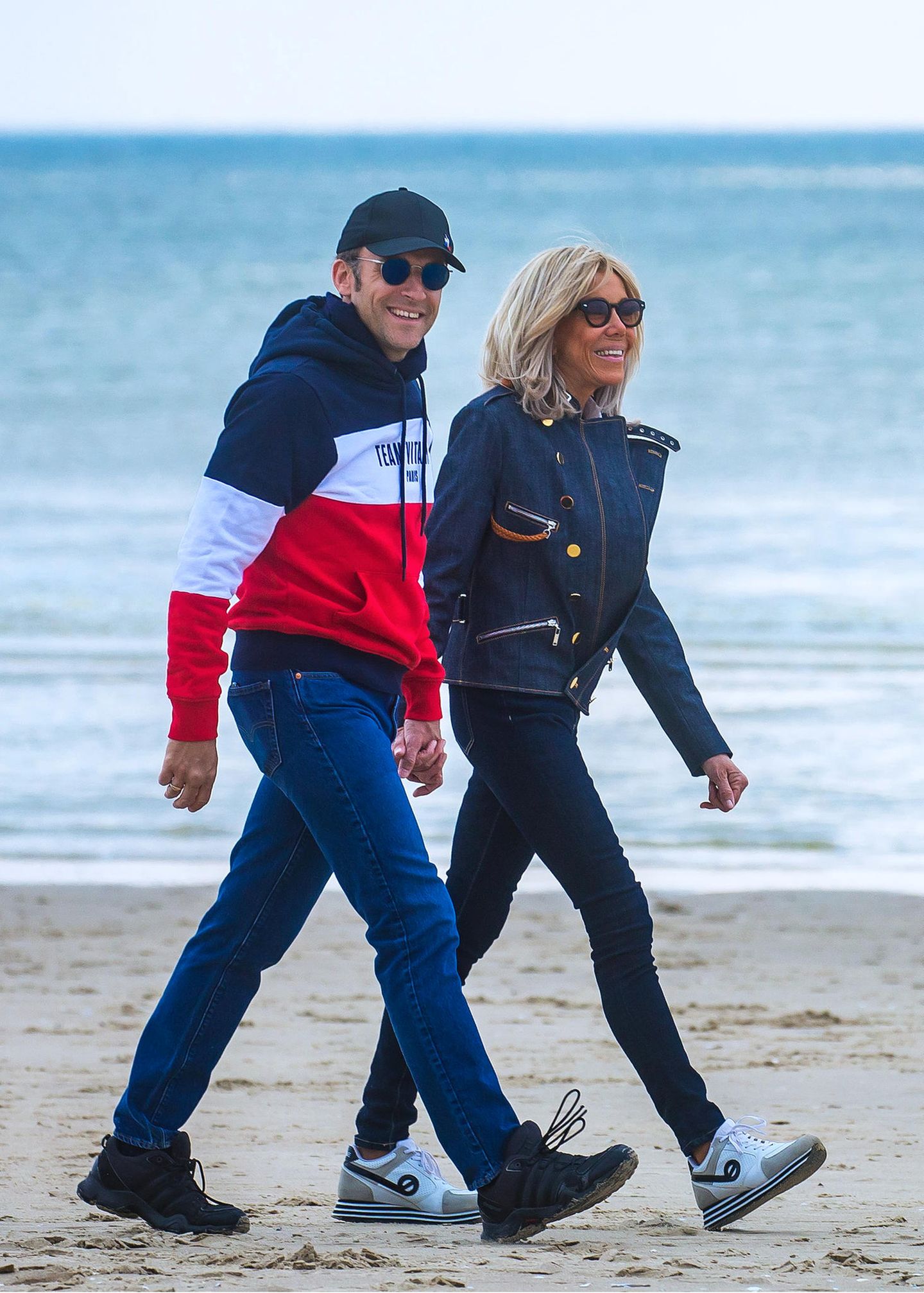 Am Tag vor der entscheidenen Stichwahl in Frankreich gönnen sich Präsident Macron und seine Frau Brigitte noch einmal einen entspannten Spaziergang am Strand von Le Touquet. Beide sind dabei natürlich ganz auf die Farben der Nationalflagge eingestimmt, und die Première Dame könnte in ihrem dunkelblauem Denim-Outfit mit Turnschuhen kaum lässiger aussehen.