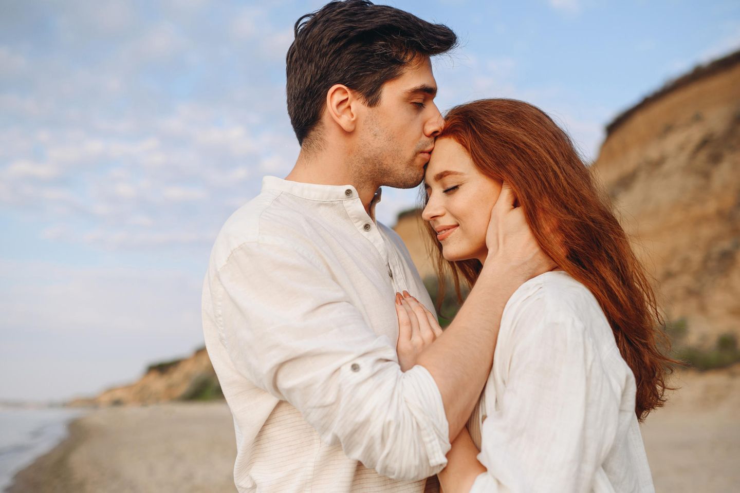 Relación simbiótica: un hombre le da a una mujer un beso amoroso en la frente