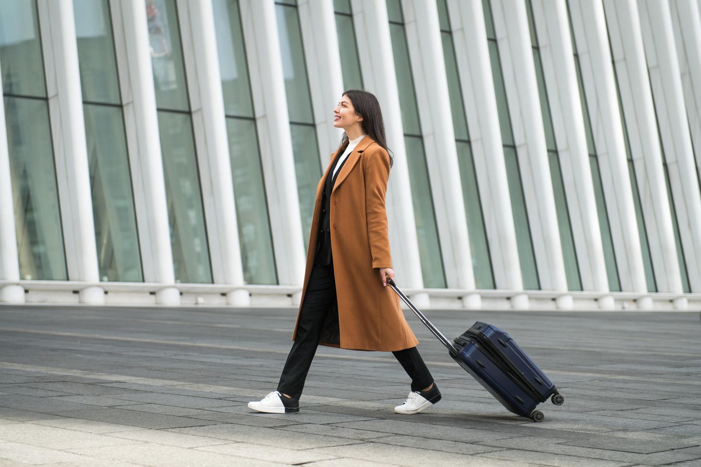 brünette Frau mit eine Schwarzen Handgepäck-Koffer
