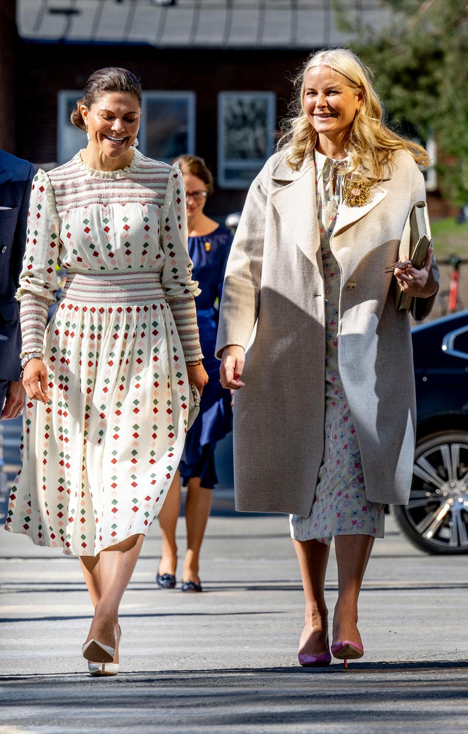 Bei der Ankunft des norwegischen Kronprinzenpaares in Schweden scheinen die Prinzessinnen nicht nur charakterlich auf einer Wellenlänge zu sein, auch die Outfits der beiden harmonieren perfekt miteinander. Während sich Prinzessin Victoria für ein gemustertes Kleid mit Statement-Ohrringen entscheidet, verzaubert Prinzessin Mette-Marit von Norwegen in einem hellen Kleid mit Blumen-Print. Ihr Outfit rundet die 48-Jährige mit einem beigen Mantel und rosafarbenen Pumps ab. 