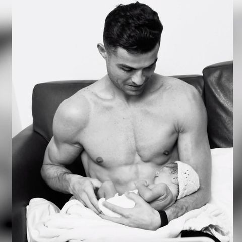 Cristiano Ronaldo hat seine Tochter auf dem Arm.