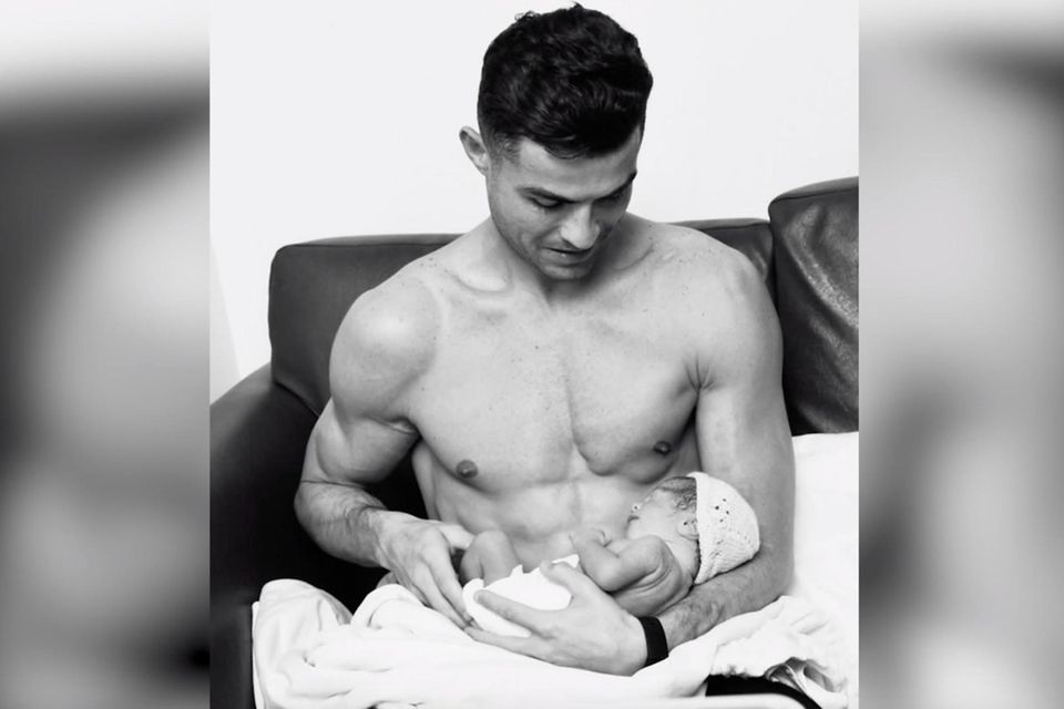 Cristiano Ronaldo hat seine Tochter auf dem Arm.