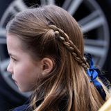 Auch Prinzessin Charlottes seidene Haarschleife, die die beiden geflochtenen Zöpfe zusammenhält, ist dunkelblau.