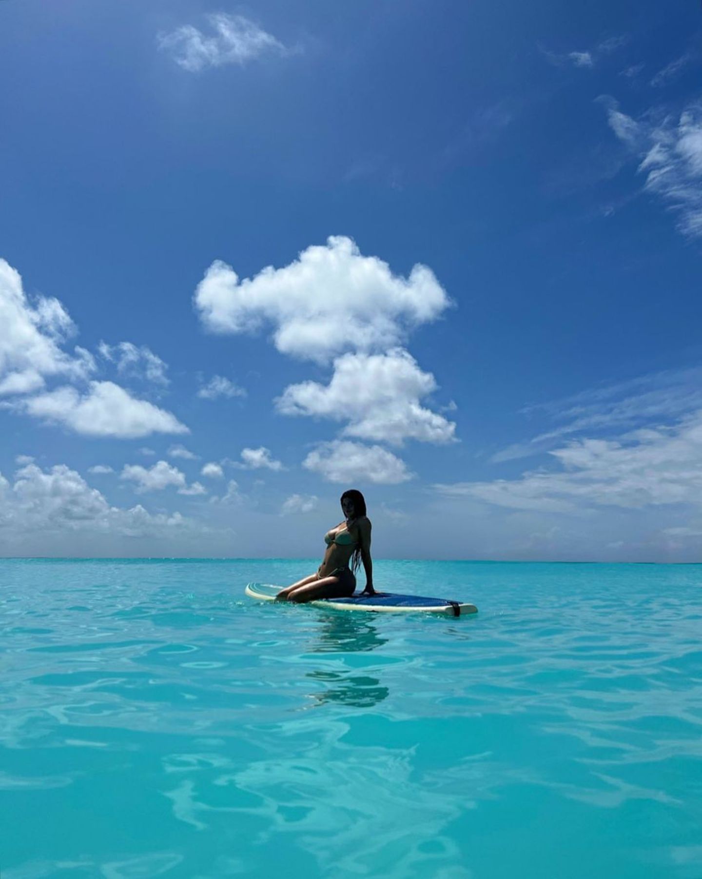 Kylie Jenner kann sich wirklich glücklich schätzen, unter blauem Himmel sonnt sie sich im türkisfarbenen Meer auf einem Surfboard. Und kommentiert diese paradiesische Szene entsprechend mit "happy girl".
