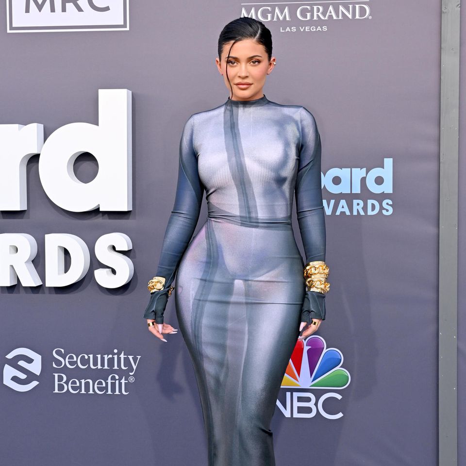 Kylie Jenner liebt den sexy Auftritt und entscheidet sich daher auch bei den Billboard Music Awards 2022 für eine hautenge graue Robe von Balmain, die ihre Rundungen perfekt in Szene setzt. Bei den Accessoires setzt sie auf breite goldene Armreifen. 