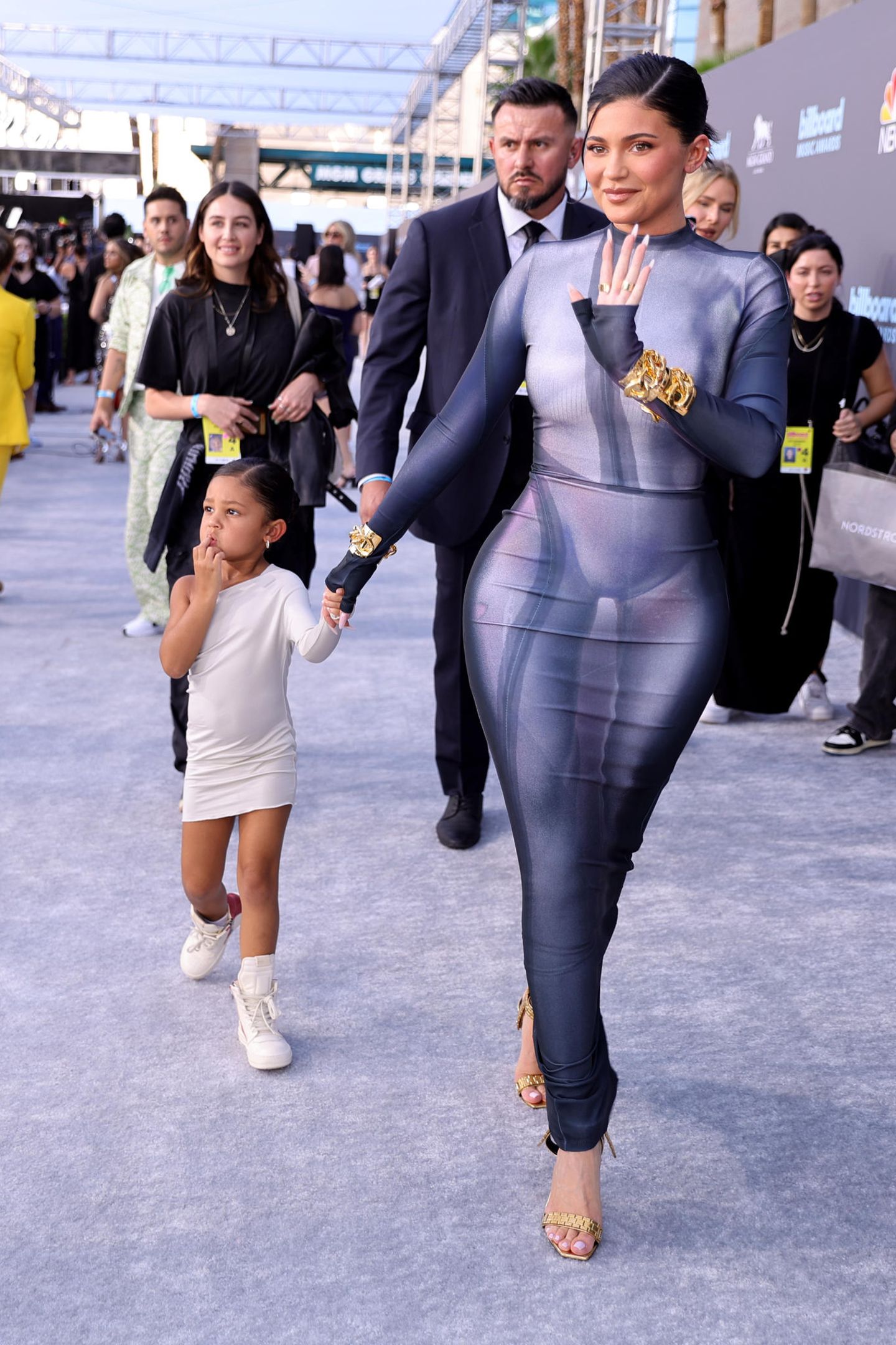 Stormi Webster teilt ganz offensichtlich den Modegeschmack ihrer Mama: Sie begleitet Kylie Jenner im eng anliegenden weißen One-Shoulder-Kleid auf den roten Teppich. Dazu trägt die 4-Jährige coole weiße Sneaker mit hohem Schaft.