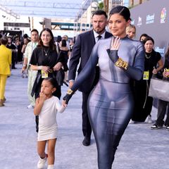 Stormi Webster teilt ganz offensichtlich den Modegeschmack ihrer Mama: Sie begleitet Kylie Jenner im eng anliegenden weißen One-Shoulder-Kleid auf den roten Teppich. Dazu trägt die 4-Jährige coole weiße Sneaker mit hohem Schaft.