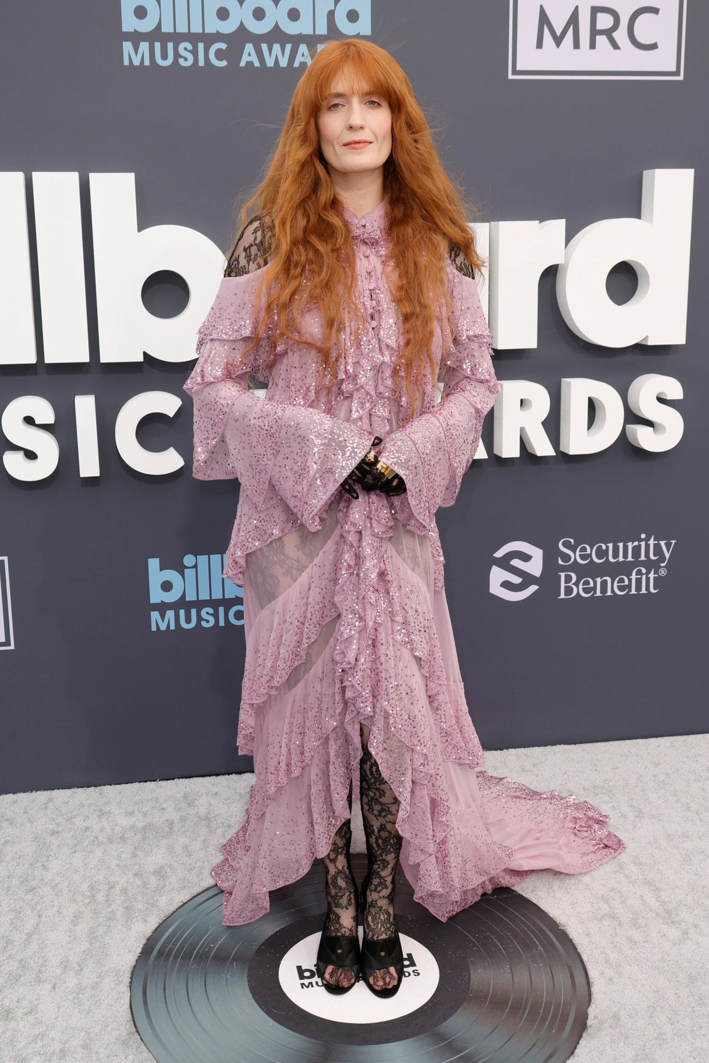 Florence Welch ist bekannt für ihre besonderen Looks. Über einem Ganzkörperanzug aus Spitze trägt die Frontfrau von "Florence + the Machine" ein weites rosa Kleid von Pailletten, Rüschen und Cut Outs von Gucci.