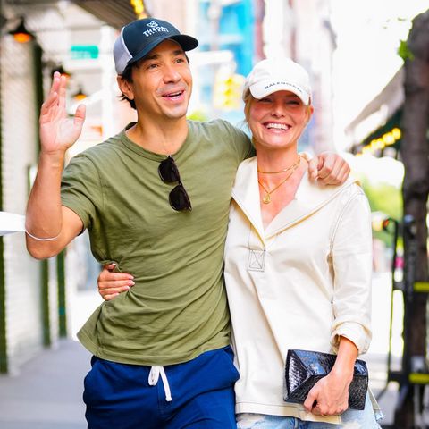 Justin Long und Kate Bosworth laufen Arm in Arm auf einem Gehweg.
