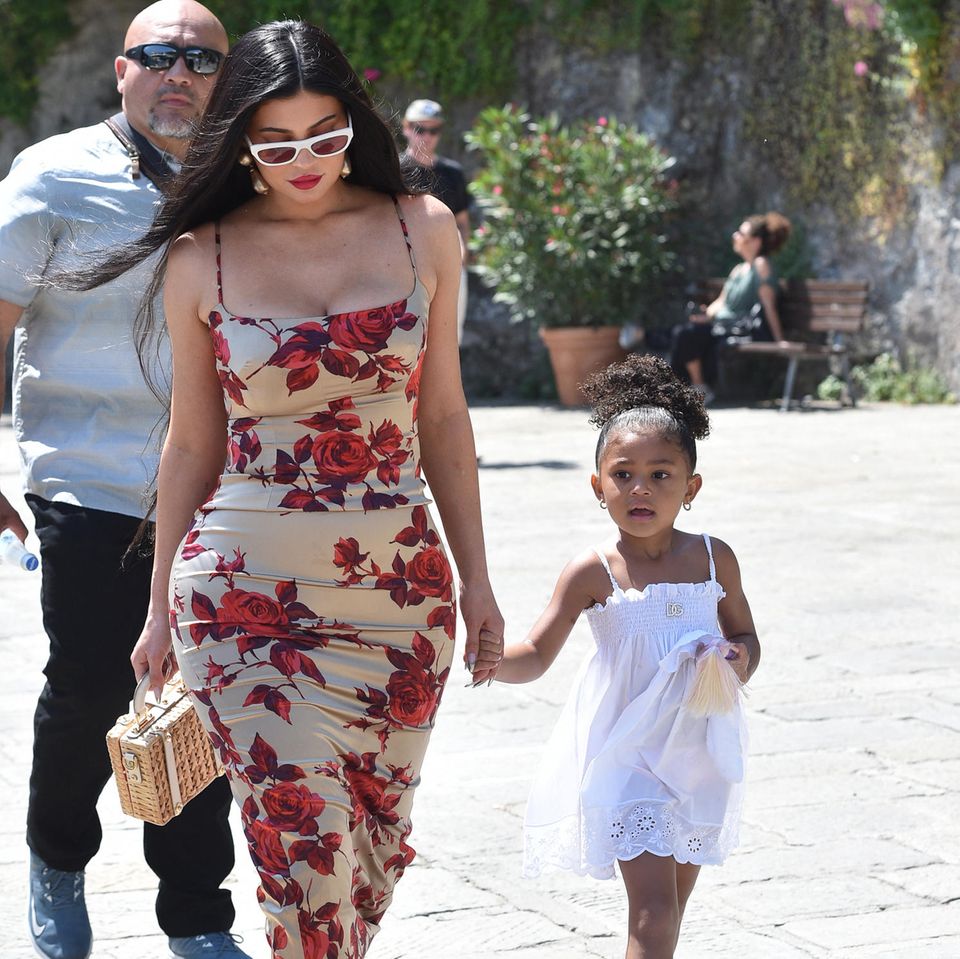 Kylie Jenner ist mit Tocher Stormi auf dem Weg zum vor-hochzeitlichen Bootsausflug mit der gesamten Kardashian-Familie. Dafür trägt die 24-Jährige ein enganliegendes Blumenkleid von Dolce & Gabbana, Stormi ein weißes Sommerkleidchen der Designer. 