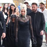 Kim Kardashian zeigt sich für die tatsächliche Hochzeit in einem hochgeschlossenen schwarzen Spitzenkleid von Dolce & Gabbana mit integrierten Handschuhen. Dazu setzt die 40-Jährige auf eine massive Kreuzkette. 