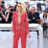 Schauspielerin Kristen Stewart präsentiert sich beim Photocall für ihren neuen Film "Crimes Of The Future" im roten Tweed-Anzug von Chanel. Die weit aufgeknöpfte Jacke, derbe schwarze Boots und die gelbe Pilotenbrille brechen den klassischen Look ab. 