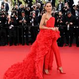 Als hätten sie sich mit Diane Kruger abgesprochen – Izabel Goulart setzt in Cannes ebenfalls auf den Lady-in-Red-Look. Obwohl das Outfit sich ähnelt, ist das Label ein anderes. Izabels Jumpsuit mit langer Feder-Schleppe ist auf dem Haus Ashi Studio. 