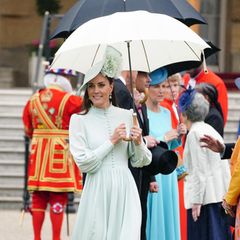 Zur dritten Royal Garden Party im Buckingham Palast in London erscheint Herzogin Catherine in einem hochgeschlossenem Midi-Kleid mit sichtbarer Knopfleiste und Puffärmeln. Bei dem mintfarbenen Kleid, designt von ihrem privaten Schneider, handelt es sich um einen Recycler: Die Dreifach-Mama trug es bereits zum 50. Jahrestag von Prinz Charles' Amtseinführung. Und wie sollte es bei Kate anders sein: Hut, Schuhe und sogar der Regenschirm sind farblich auf das Kleid abgestimmt. 