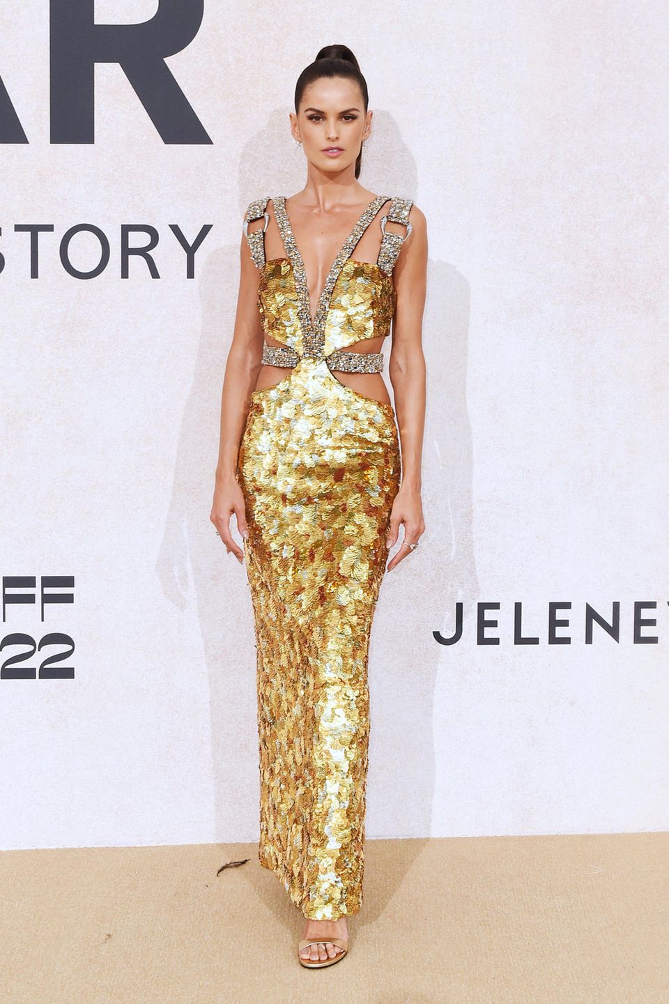 Im gold-glitzernden Pailletten-Look von Roberto Cavalli hat Topmodel Izabel Goulart einen besonders glamourösen Auftritt auf dem Teppich der amfAR Gala.