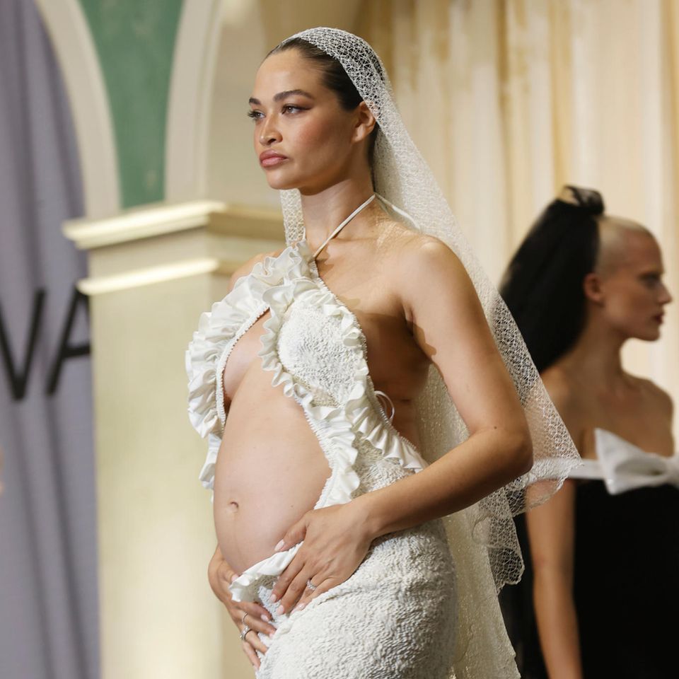 Was für ein Look! Auf dem Laufsteg der amfAR Cannes Gala 2022 präsentiert Model Shanina Shaik ihren Babybauch im besten Licht. In dem Kleid kommt er besonders gut zur Geltung, da die Cut-Outs genau an der richtigen Stelle sitzen.