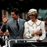 Prinz Charles und Prinzessin Diana winken den Menschen aus einem Auto zu.