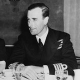 Lord Louis Mountbatten sitzt an einem Tisch.