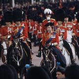Die Queen reitet bei einer Truppenparade auf ihrem Pferd an ihrem Volk vorbei.