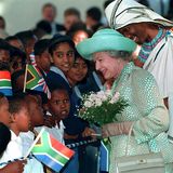 Die Queen lächelt die vielen Kinder vor sich an.