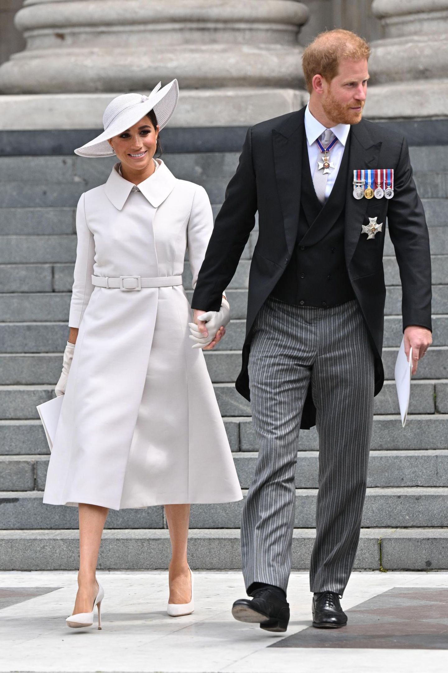 Bei ihren spitzen Pumps, ihren Lederhandschuhen (beides von Christian Dior) und ihrem Schmuck bleibt Herzogin Meghan ebenfalls in der neutralen Farbfamilie und kreiert somit einen edlen Monochrom-Look, der bei den Fans jedoch nur bedingt gut ankommt. Denn kritische Stimmen beschweren sich über die Designer-Wahl für ihre Rückkehr nach Großbritannien. "Warum muss Meghan unbedingt ein französisches Label tragen?" und "Hätte Meghan keinen britischen Designer supporten können?" heißt es in den sozialen Netzwerken.