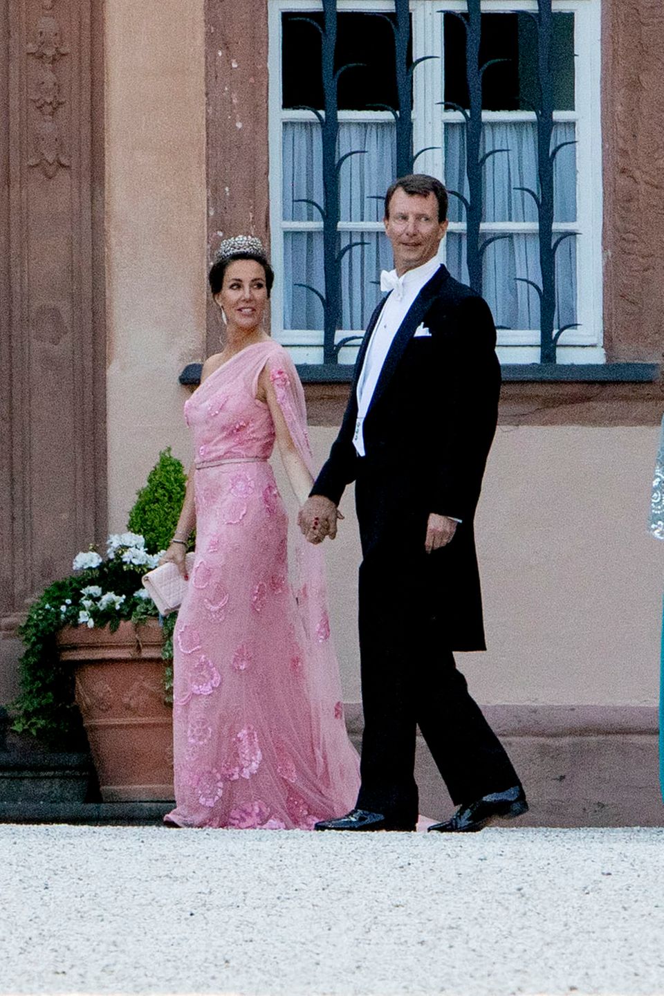 Auch Prinzessin Marie und Prinz Joachim sind zu Gast bei der Hochzeit in Bad Berleburg. Während Prinz Joachim ganz klassisch auf Frack und Hemd setzt, begeistert Mary in einer rosafarbenen Spitzenrobe mit floralen Stickereien.