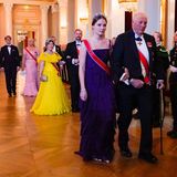 Nach der Fotosession geht es für die Royals zum Galadinner. In einem wunderschönen dunkelvioletten Kleid geleitet Prinzessin Ingrid Alexandra König Harald in den Speisesaal des Osloer Schlosses.