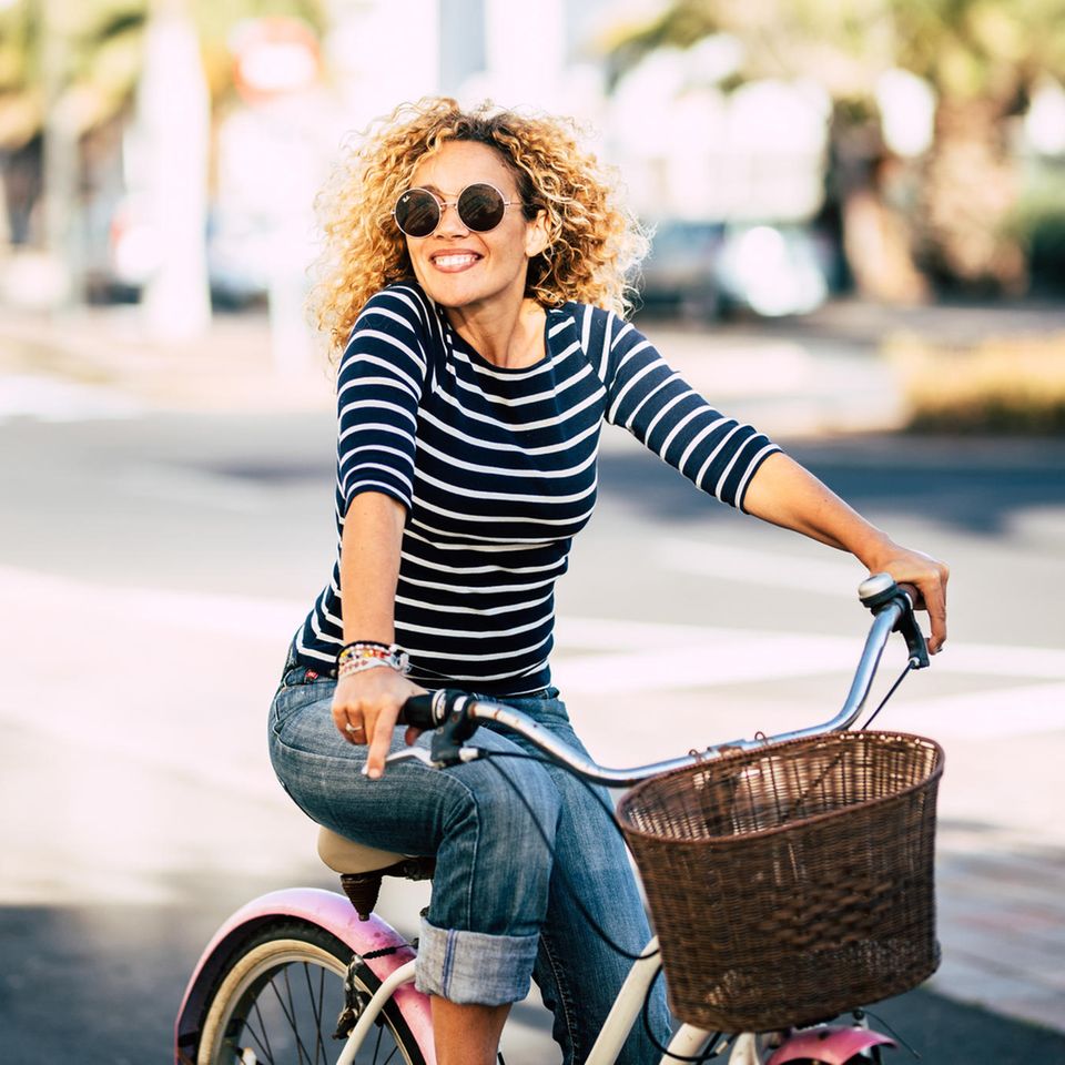 Entspannte Frau fährt Fahrrad: Diese 4 Merkmale zeichnen unkomplizierte Menschen aus