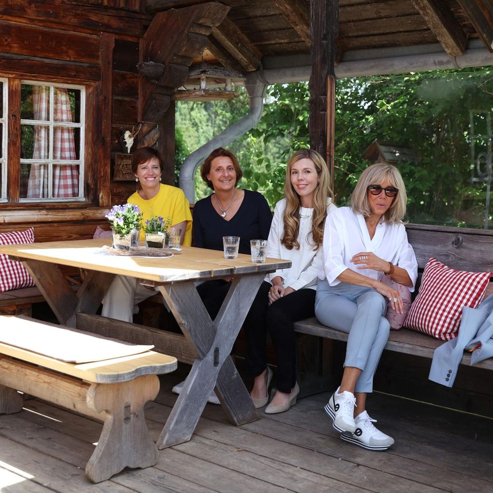 Amélie Derbaudrenghien, Britta Ernst, Carrie Johnson und Brigitte Macron (v.l.n.r.) sitzen am 27. Juni 2022 während des Ehepartnerprogramms am Rande des G7-Gipfels in Elmau, Süddeutschland, vor einer Berghütte zusammen. 