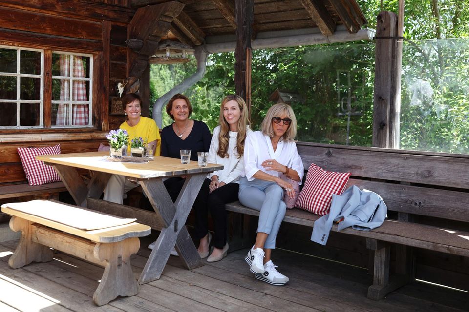 Amélie Derbaudrenghien, Britta Ernst, Carrie Johnson und Brigitte Macron (v.l.n.r.) sitzen am 27. Juni 2022 während des Ehepartnerprogramms am Rande des G7-Gipfels in Elmau, Süddeutschland, vor einer Berghütte zusammen. 
