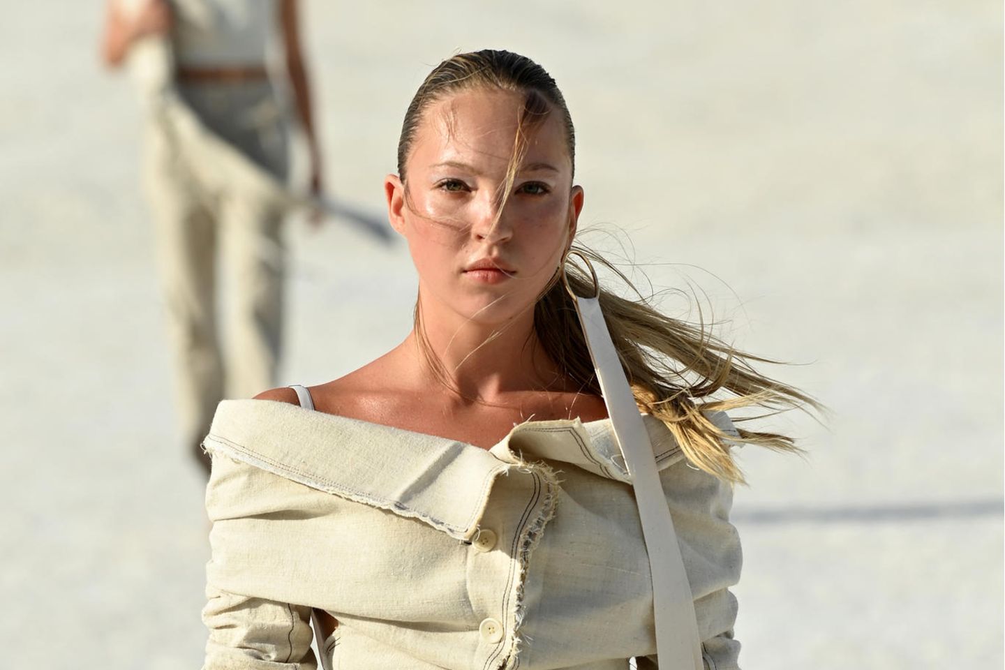 Lila Moss war ebenfalls Teil derJacquemus Fashion Show in Arles – die Tochter von Kate Moss ist noch nicht all zu lange Zeit auf Laufstegen zu sehen. In der Show trägt sie ein beiges Set aus langer Hose und einem distressed Blazer mit Carmen-Ausschnitt.
