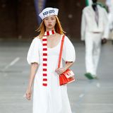 Die Kenzo Spring Summer 2023 Show war Teil der Paris Fashion Week. Dieser Look aus einem weißen Kleid mit Lochmuster, einem gestreiften Schal und roten Accessoires wie Tasche und Schuhe war eines der vielen Highlights der Fashion Show.