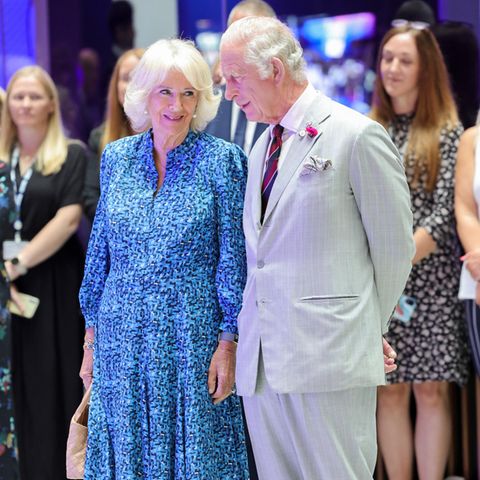 Herzogin Camilla und Prinz Charles schauen sich verschmitzt an.