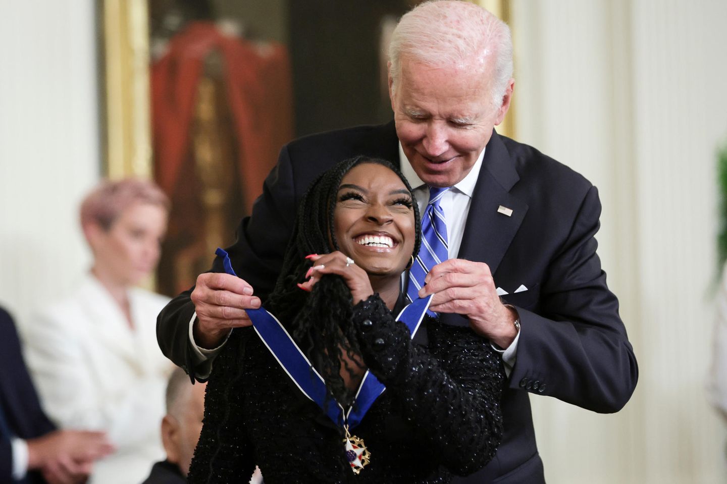 Joe Biden übergibt Simone Biles eine Medaille.