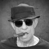 Klaus Lemke posiert mit einer Zigarre im Mund.