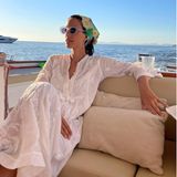 Alessandra de Osma genießt ihren Urlaub in vollen Zügen. Nach dem erfrischenden Bad im Meer wirft sie sich ein weißes Tunikakleid über, mit aufwendigen Stickereien, dazu kombiniert sie ein gehäkeltes Kopftuch. 