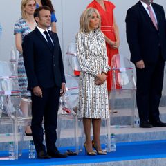 Bei der Militärparade zum Nationalfeiertag auf der Avenue des Champs-Elysees am 14. Juli 2022 in Paris,  zeigt sich Brigitte Macron in einem hochgeschlossenem Seidenkleid mit Schluppen-Detail und Taillengürtel. Der Schlüssel-Print lässt auf das Designerhaus Louis Vuitton schließen. 