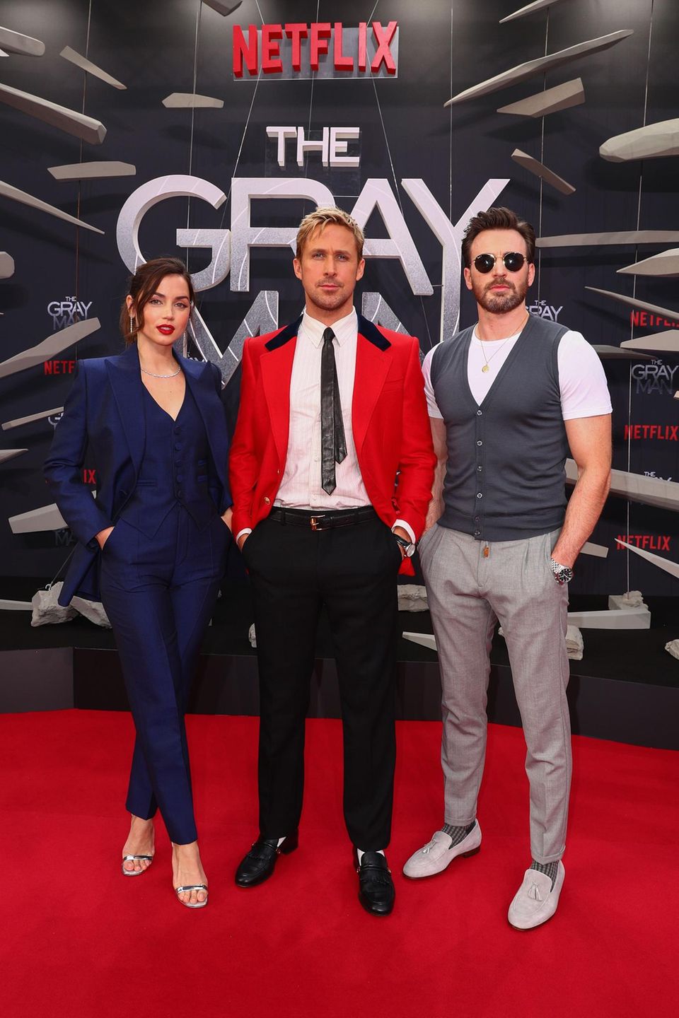 Beim Netflix Special Screening ihres neuen Films "The Gray Man" in Berlin machen die Hauptdarsteller eine gute Figur. Das Jacket von Ryan Gosling passt zum roten Teppich, Ana de Armas präsentiert sich in einem nachtblauen Jumpsuit, darüber trägt sie einen Blazer im gleichen Farbton. Ihre Lippen betont die Schauspielerin in leuchtendem Rot. Chris Evans tritt mit Sonnenbrille vor die Kameras. Das Outfit des 41-Jährigen ist schlicht und zurückhaltend. Er trägt eine dunkelgraue Weste über einem weißen T-Shirt, dazu kombiniert er eine Stoffhose und Slipper – ebenfalls in Grau. Beim Netflix Special Screening ihres neuen Films "The Gray Man" in Berlin machen die Hauptdarsteller eine gute Figur. Das Jacket von Ryan Gosling passt zum roten Teppich, Ana de Armas präsentiert sich in einem nachtblauen Jumpsuit, darüber trägt sie einen Blazer im gleichen Farbton. Ihre Lippen betont die Schauspielerin in leuchtendem Rot. Chris Evans tritt mit Sonnenbrille vor die Kameras. Das Outfit des 41-Jährigen ist schlicht und zurückhaltend. Er trägt eine dunkelgraue Weste über einem weißen T-Shirt, dazu kombiniert er eine Stoffhose und Slipper – ebenfalls in Grau.