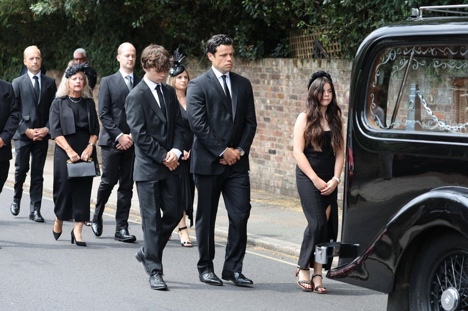 Deborah James' husband Sebastien Bowen escorts her casket to church with their children, Hugo and Eloise, and other family members