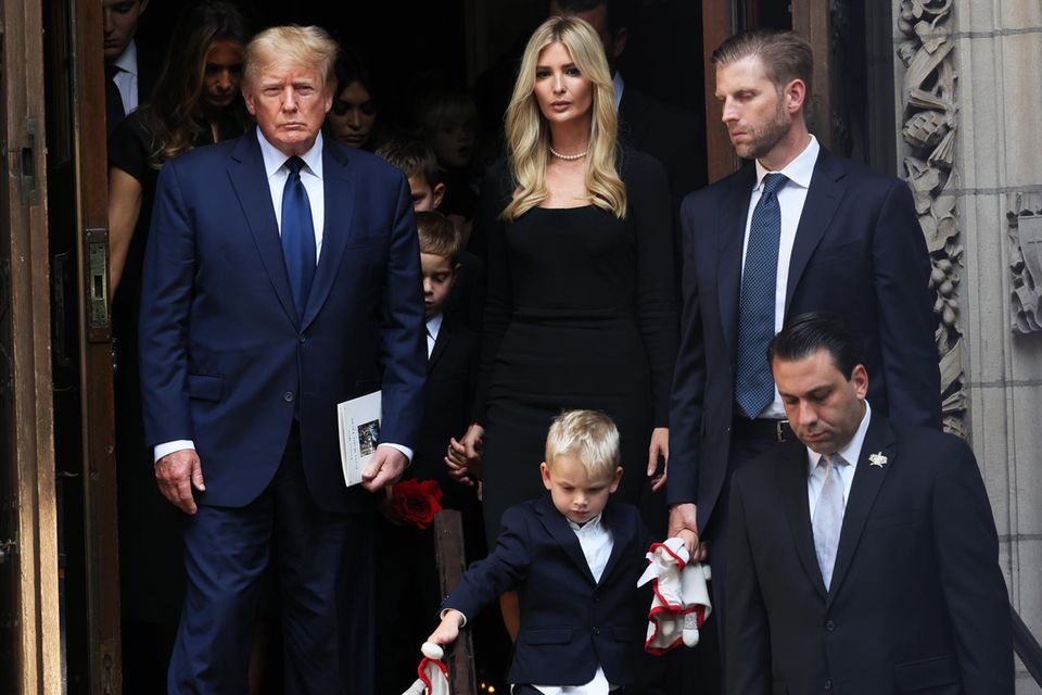 Donald Trump leaves the church with his children Ivanka (left) and Eric (right) after the funeral service.