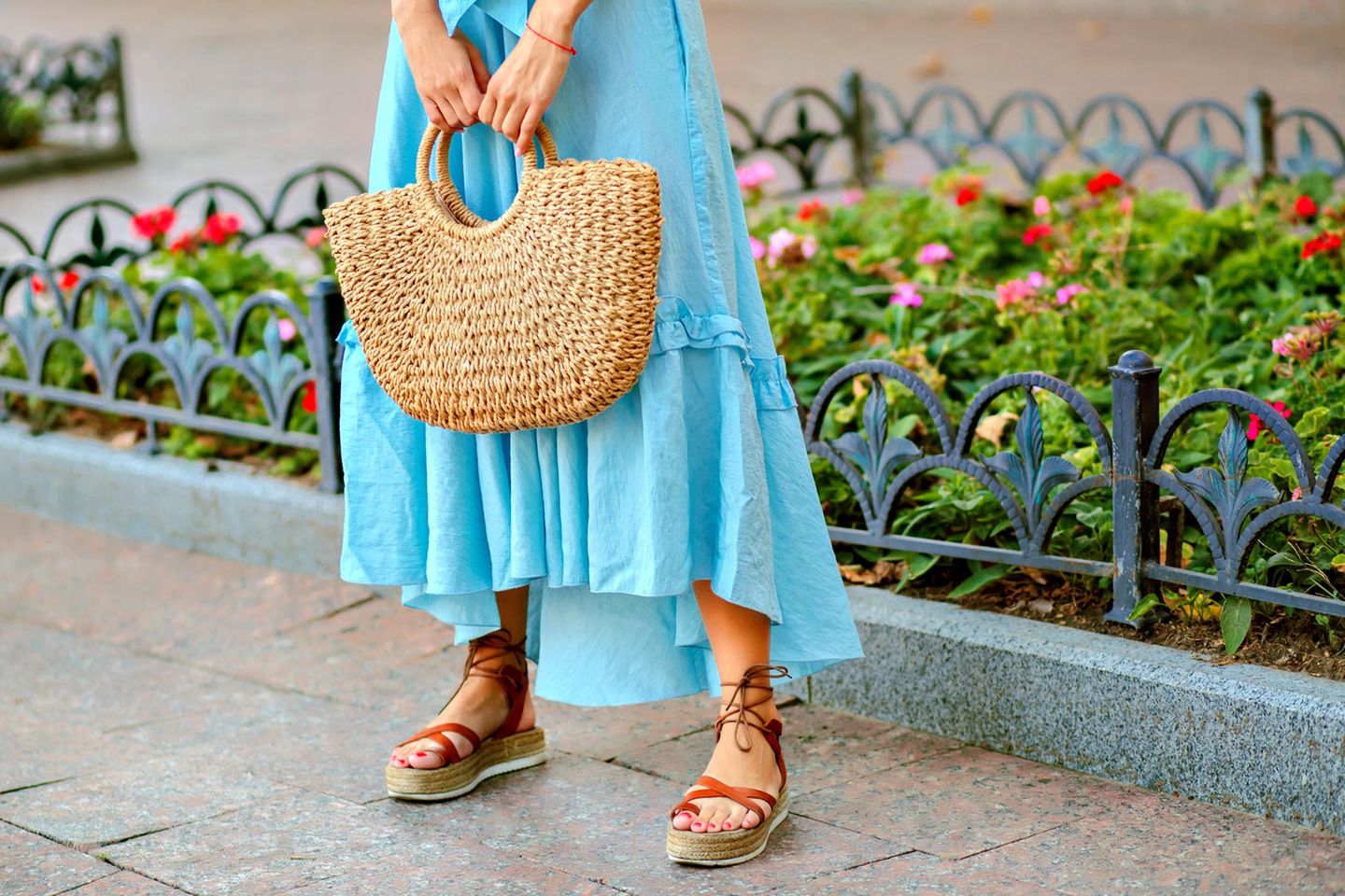 Nahaufnahme einer jungen Frau mit blauem Sommerkleid und Plateau-Sandalen