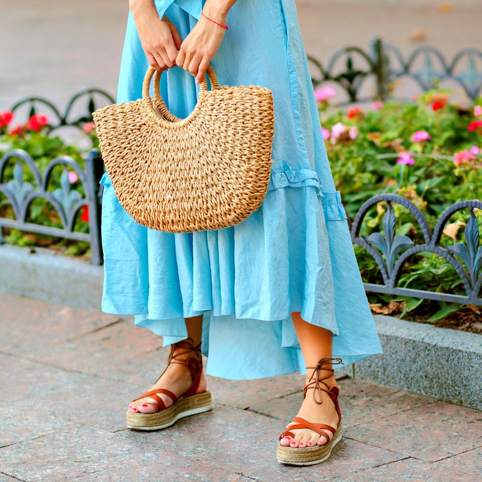 Nahaufnahme einer jungen Frau mit blauem Sommerkleid und Plateau-Sandalen