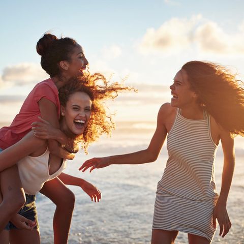Horoskop: Drei Frauen haben Spaß am Strand.