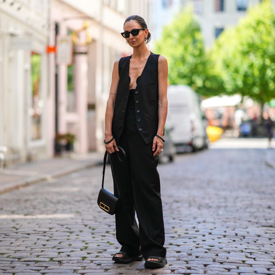 Die perfekte schwarze Hose: Frau trägt schwarze Hose und Weste